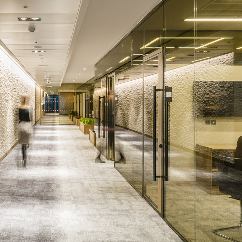 a sleek hallway with glass office doors